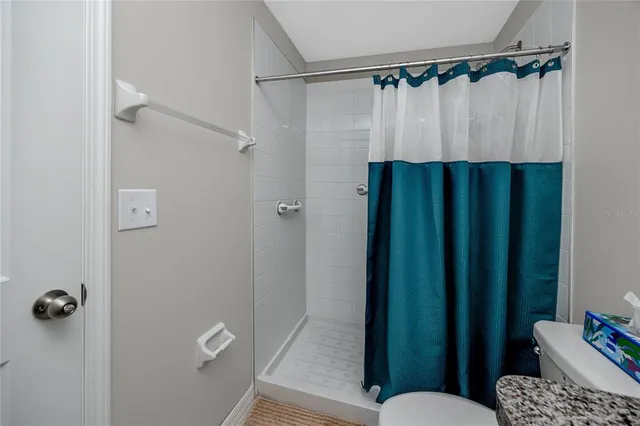 a bathroom with a shower curtain and a toilet