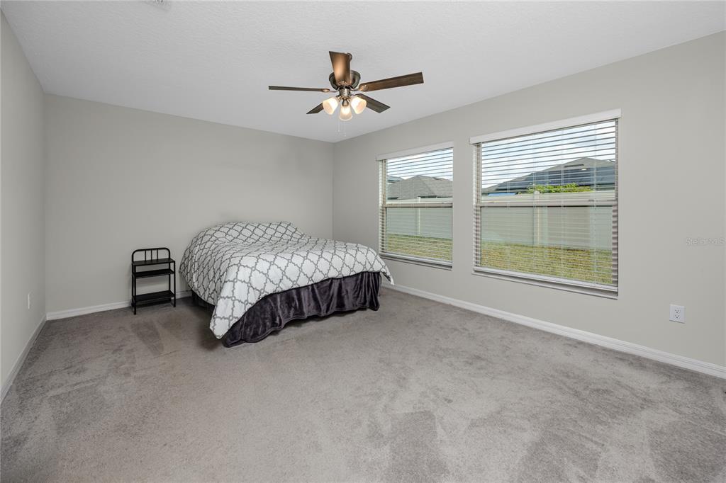 16654 Carlton Pond Street Wimauma, FL 33598 - Photo 28 of 48 a spacious bedroom with a bed and window