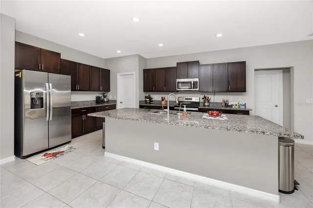 a kitchen with stainless steel appliances a refrigerator a stove a sink a microwave a counter top and cabinets