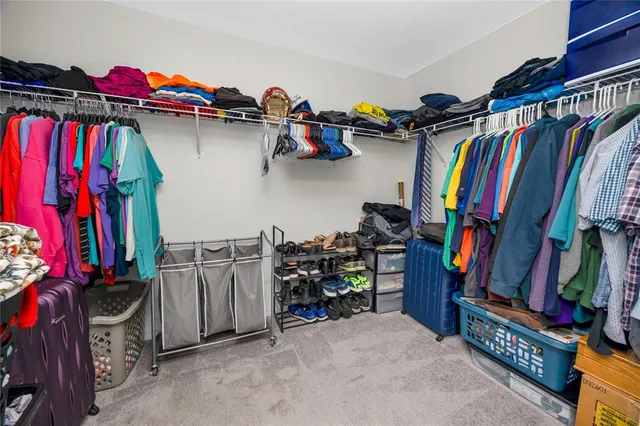 a view of walk in closet with clothes and shoes