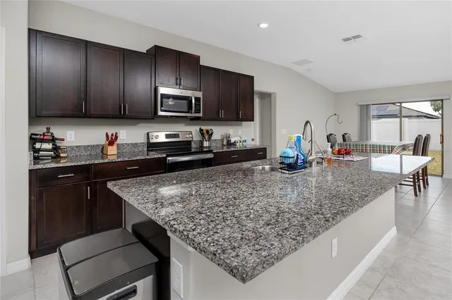 a kitchen with stainless steel appliances granite countertop a sink stove and refrigerator