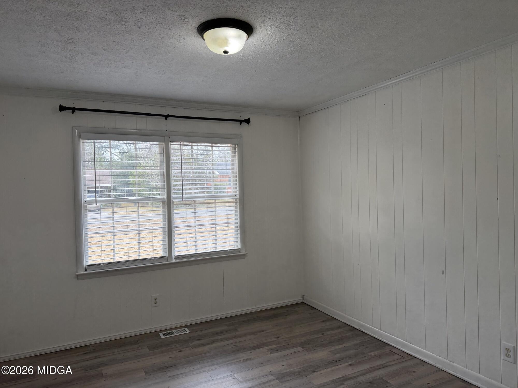 229 Southwest Peter Street Cochran, GA 31014 - Photo 14 of 24 an empty room with wooden floor and windows