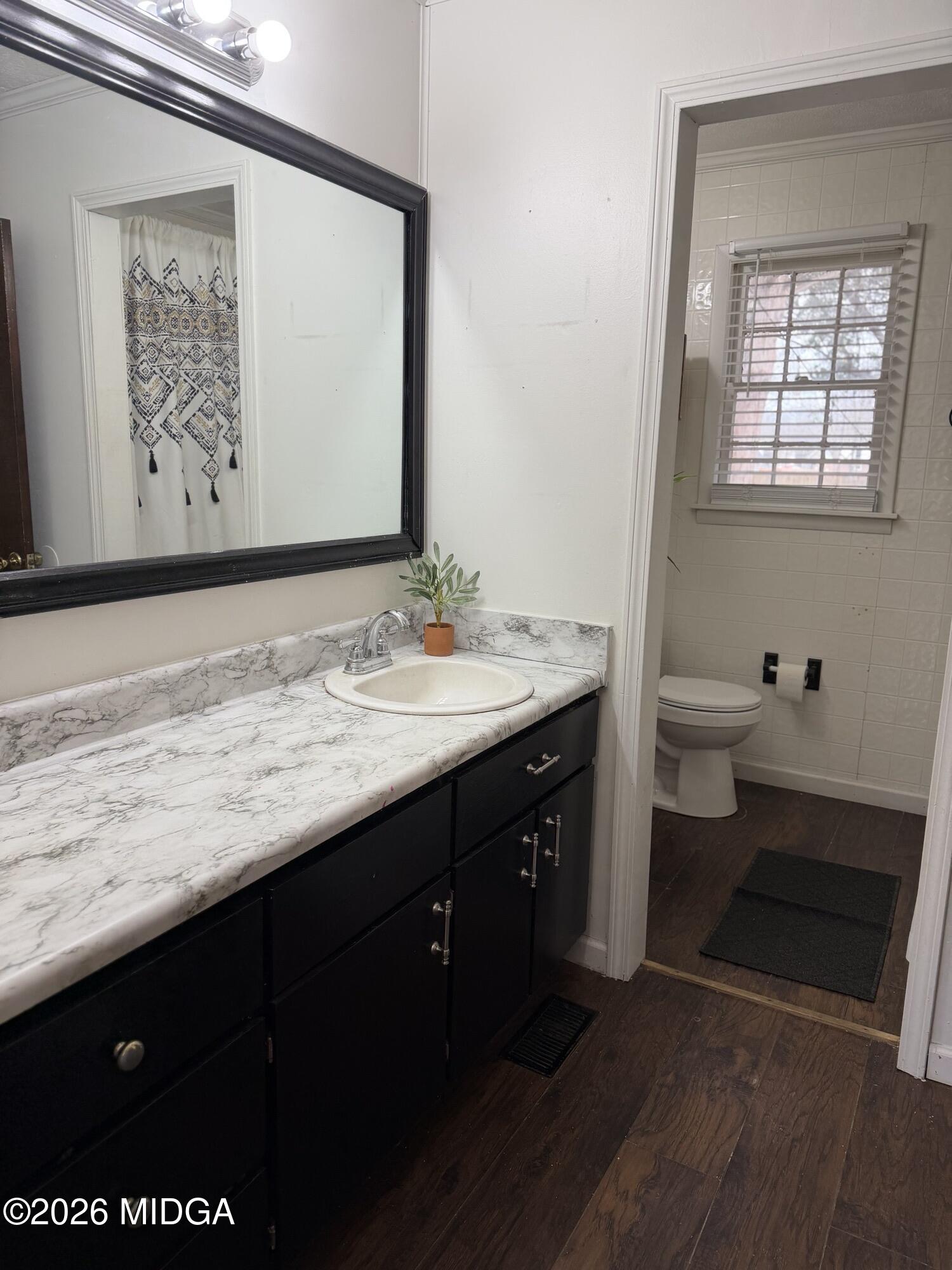 229 Southwest Peter Street Cochran, GA 31014 - Photo 16 of 24 a bathroom with a granite countertop sink a toilet and a mirror