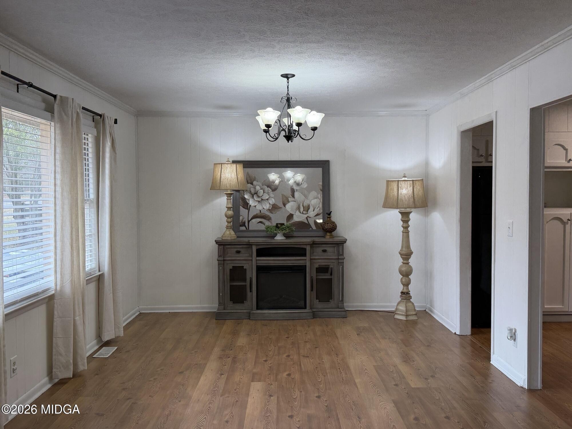 229 Southwest Peter Street Cochran, GA 31014 - Photo 4 of 24 an empty room with chandelier fan and windows