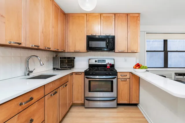 a kitchen with stainless steel appliances granite countertop a sink and a stove