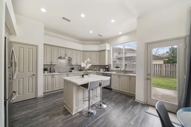 a kitchen with refrigerator cabinets and wooden floor