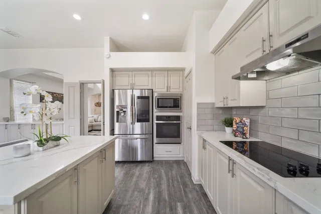 a kitchen with stainless steel appliances a sink and a refrigerator