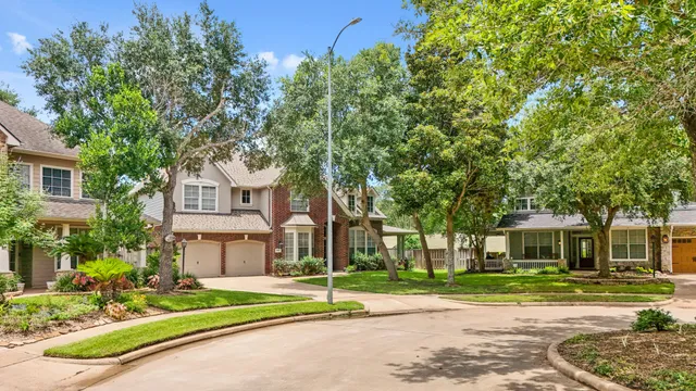 a view of a house with a yard and large tree and plants