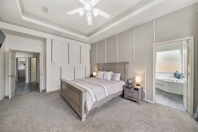 a spacious bedroom with a bed and a chandelier