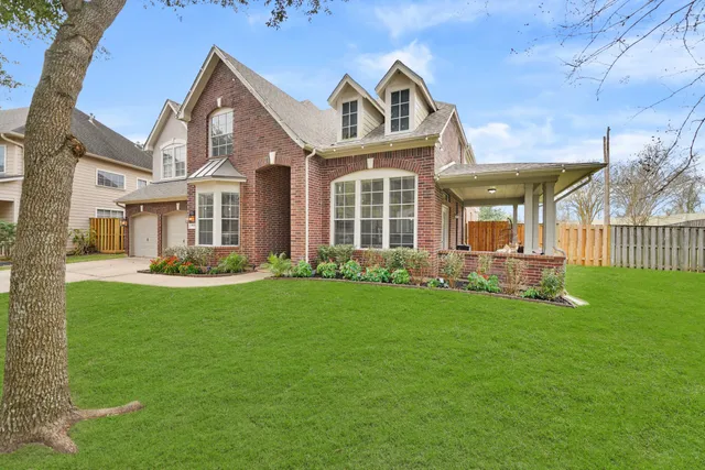a front view of a house with a garden and yard