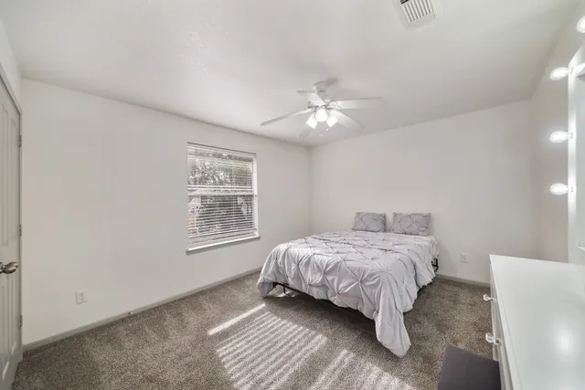 a bedroom with a bed chandelier and a window