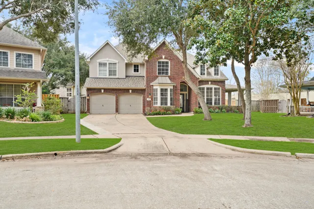 a front view of a house with a yard and trees