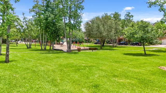 a backyard of a house with a yard and large trees