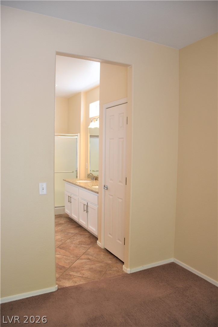 1680 Fieldbrook Street Henderson, NV 89052 - Photo 10 of 32 An open doorway leads from carpeted floors into an adjoining bathroom with tile flooring.
