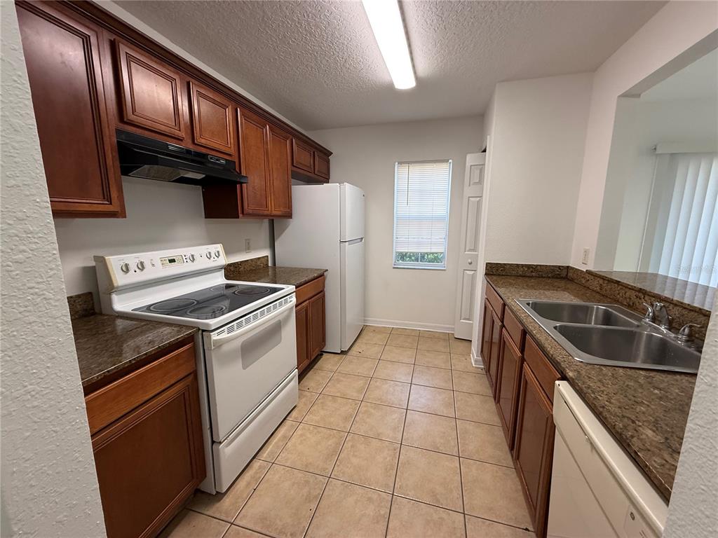 201 Drawbridge Lane Valrico, FL 33594 - Photo 5 of 11 a kitchen with granite countertop stainless steel appliances a sink stove and refrigerator