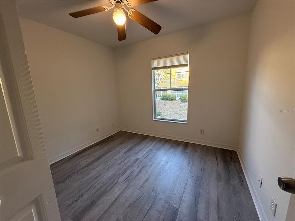 201 Drawbridge Lane Valrico, FL 33594 - Photo 8 of 11 an empty room with a window and wooden floor