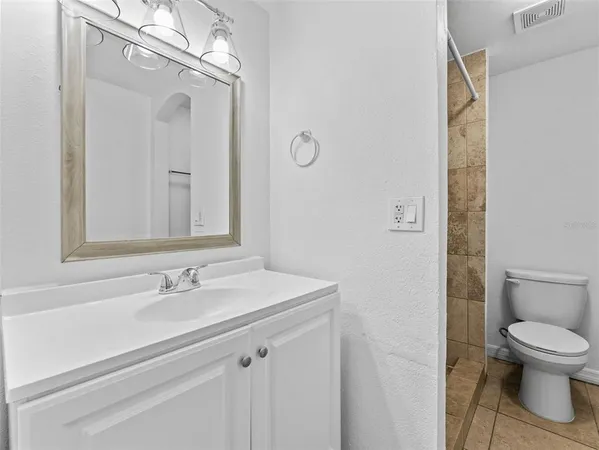 a view of patio with table and chairs potted plants and floor to ceiling window