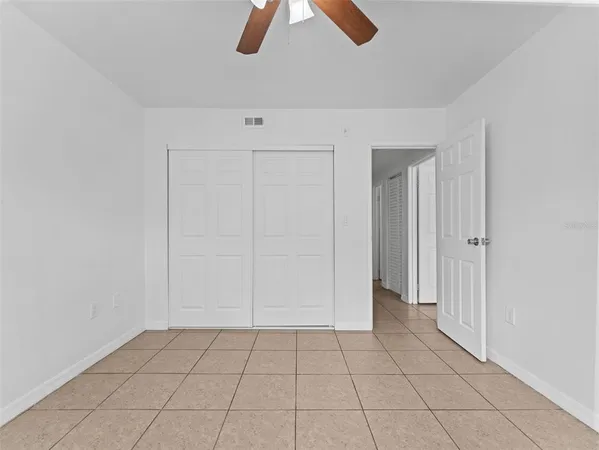 a view of empty room with wooden floor and ceiling fan