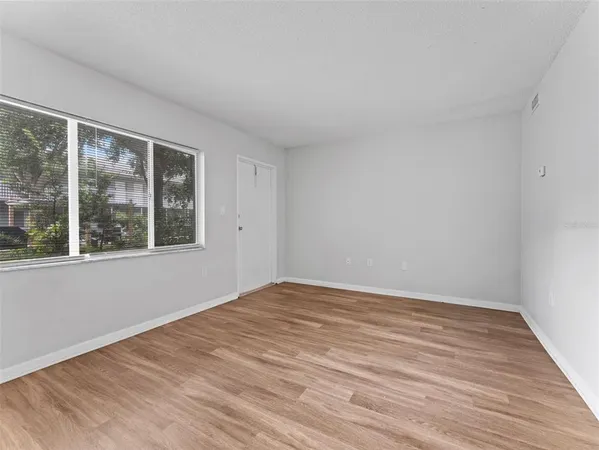a view of a patio with a table and chairs under an umbrella with potted plants