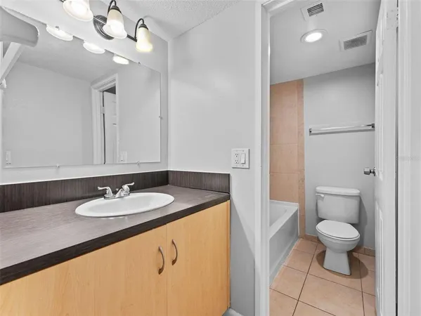 an empty room with white walls and ceiling fan