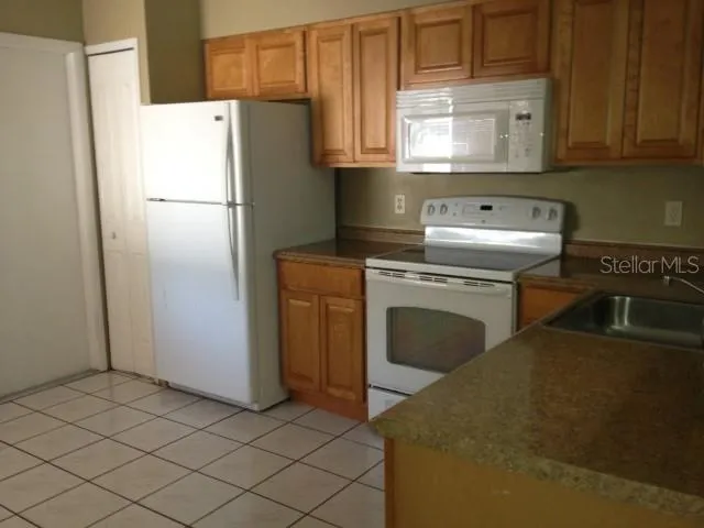 a kitchen with a stove sink and cabinets