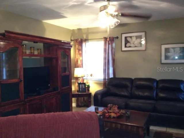a living room with furniture a flat screen tv and a window