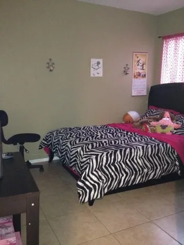 a bed sitting in a bedroom next to a window