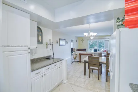 a dining hall with granite countertop a sink cabinets and stainless steel appliances