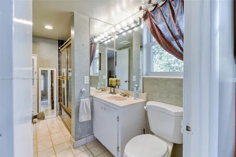 a bathroom with a sink a toilet a mirror and shower