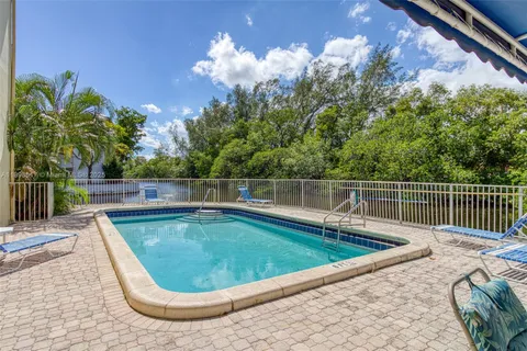 a small pool with trees in the background