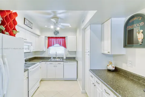 a kitchen with granite countertop a sink stainless steel appliances and cabinets
