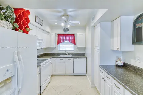 a kitchen with granite countertop a sink stainless steel appliances and cabinets