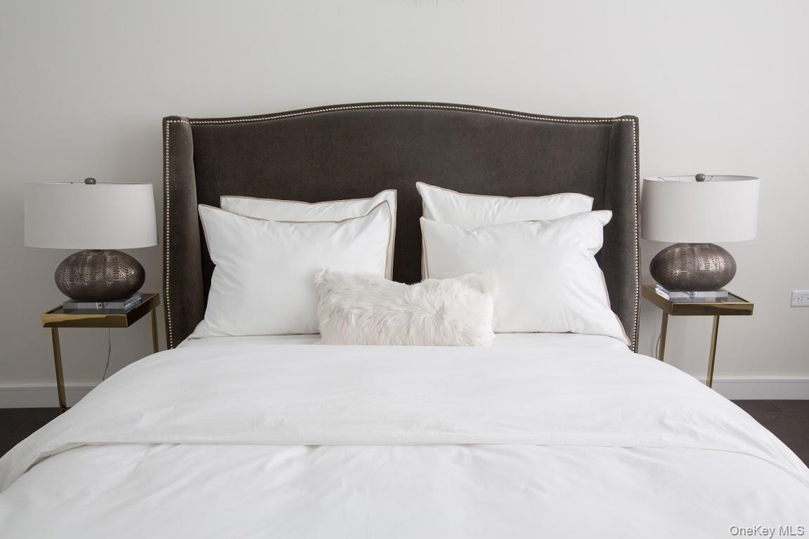 1 3rd, Unit 825 Mineola, NY 11501 - Photo 12 of 25 a bedroom with a bed and a chair