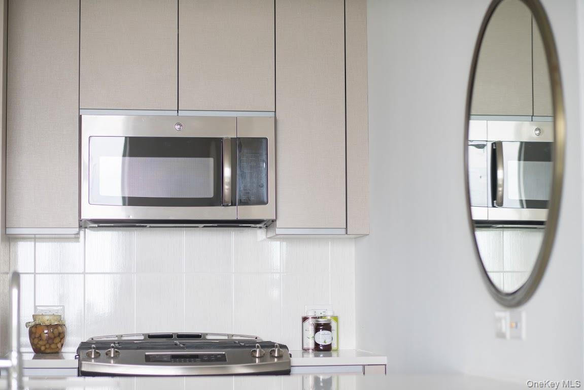 1 3rd, Unit 825 Mineola, NY 11501 - Photo 8 of 25 a bathroom with a mirror and a window