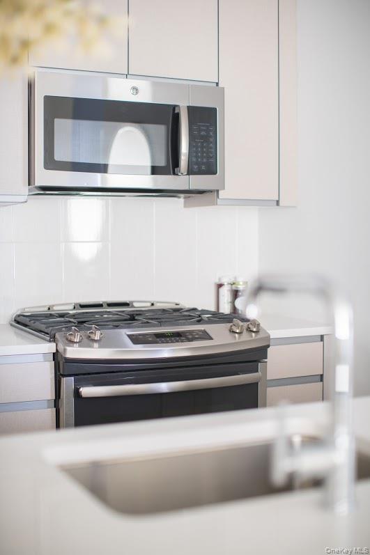 1 3rd, Unit 825 Mineola, NY 11501 - Photo 9 of 25 a living room with a stove and a cabinet