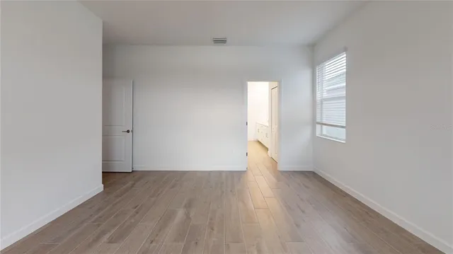 a view of a room with wooden floor and a ceiling fan