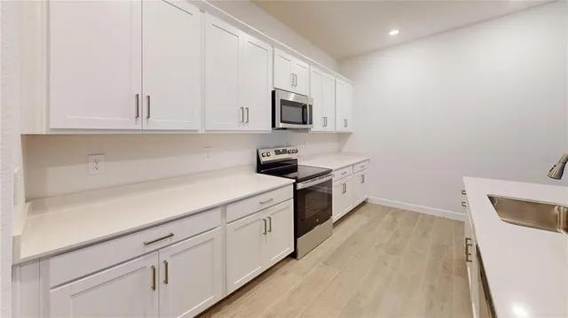 a palm tree sitting in front of a yard with palm trees