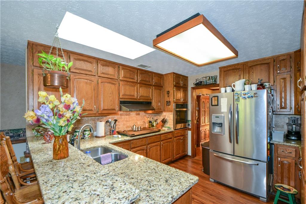 130 Hawn Road Fayetteville, GA 30215 - Photo 9 of 67 a kitchen with stainless steel appliances granite countertop sink refrigerator and microwave
