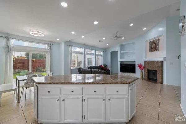 a kitchen with kitchen island granite countertop a sink a counter top space and cabinets