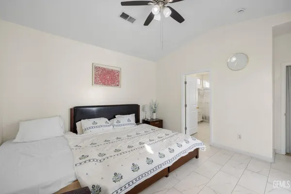 a bedroom with a bed and painting on the wall