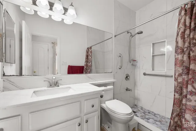 a bathroom with a sink a toilet and a mirror