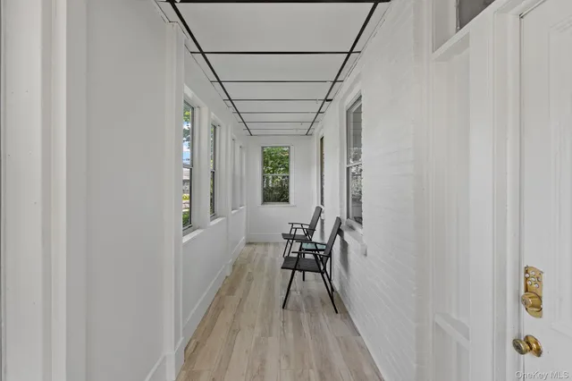 a view of a hallway with wooden floor and a chair
