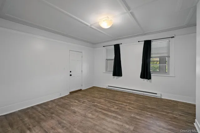 a view of an empty room with window and ceiling fan