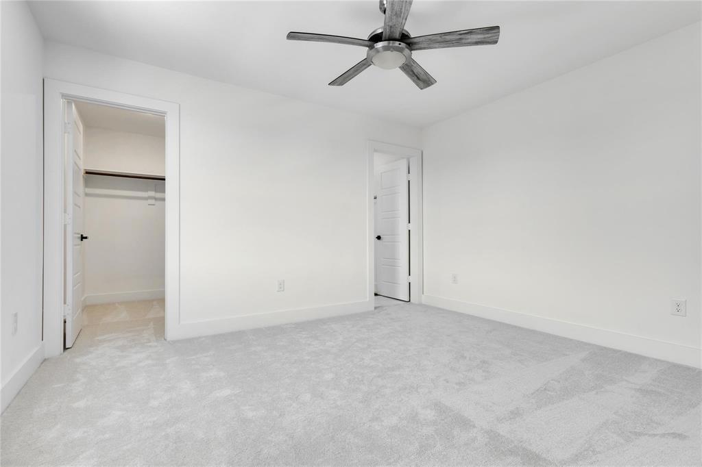 2011 Kirby Street, Unit 106 Dallas, TX 75204 - Photo 31 of 32 Unfurnished bedroom with a walk in closet, a closet, light colored carpet, and ceiling fan