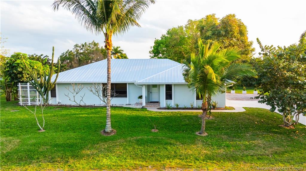 2556 Captiva Cove Stuart, FL 34994 - Photo 2 of 68 a view of a house with a backyard and a tree