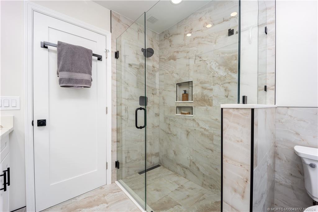 2556 Captiva Cove Stuart, FL 34994 - Photo 33 of 68 a bathroom with a shower and a glass door