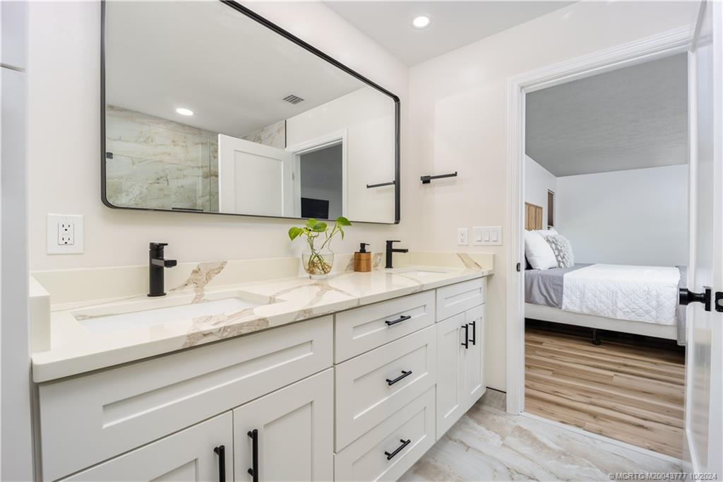 2556 Captiva Cove Stuart, FL 34994 - Photo 34 of 68 a en suite bathroom with double sink and a mirror