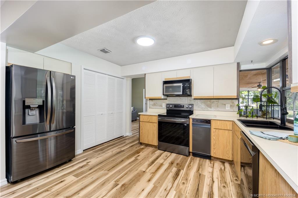 2556 Captiva Cove Stuart, FL 34994 - Photo 44 of 68 a kitchen with a refrigerator stove and sink