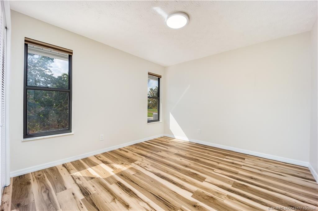 2556 Captiva Cove Stuart, FL 34994 - Photo 54 of 68 a view of a bedroom with wooden floor and windows