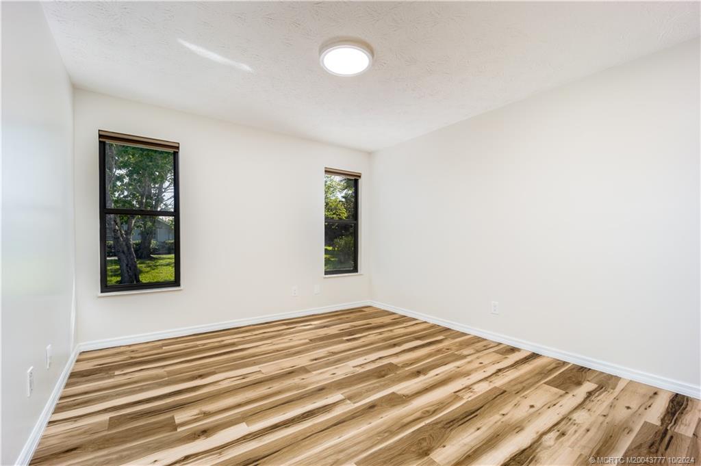 2556 Captiva Cove Stuart, FL 34994 - Photo 55 of 68 a view of a bedroom with wooden floor and windows